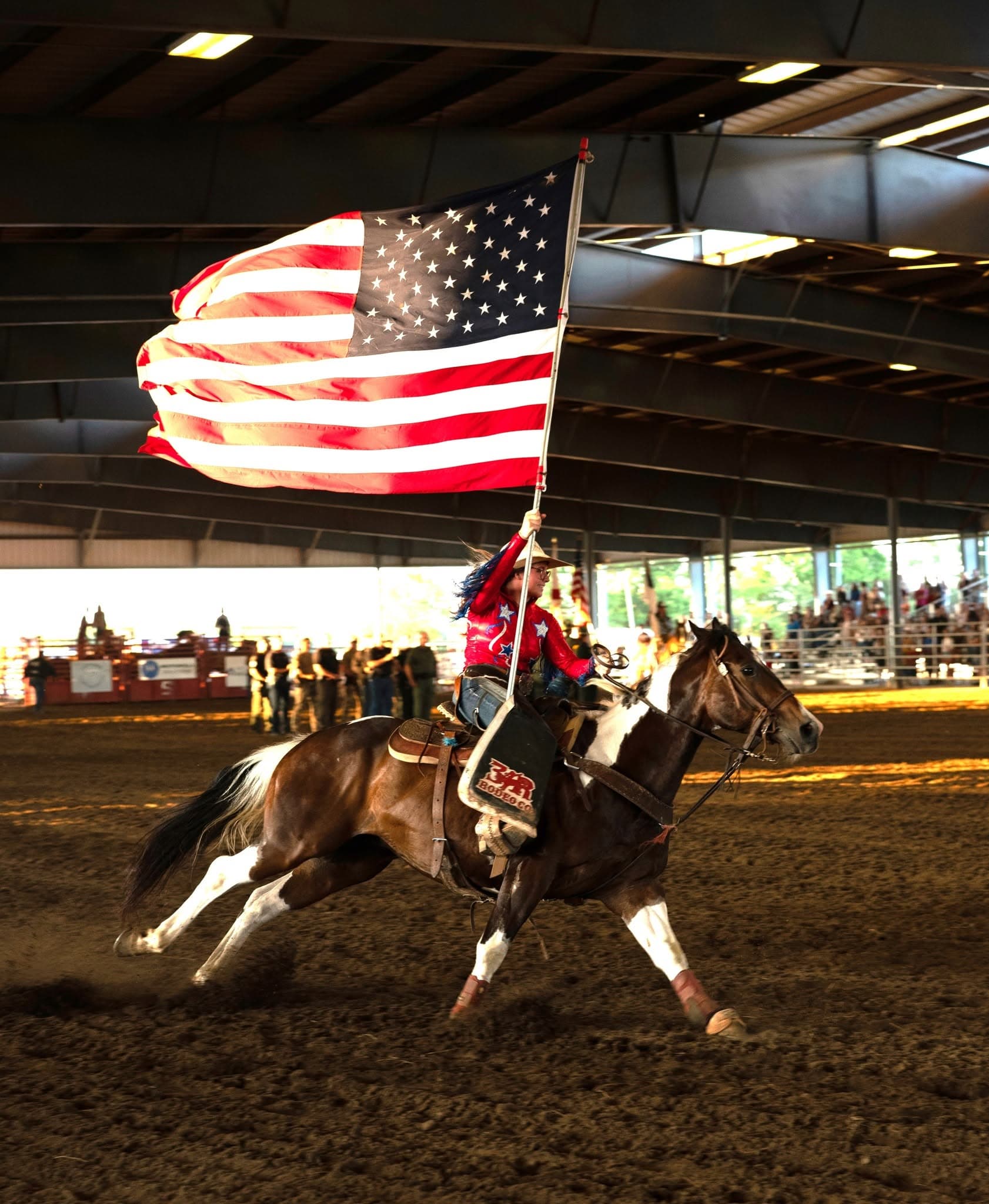 Flag bearer riding through the arena at the Sheriff’s Rodeo